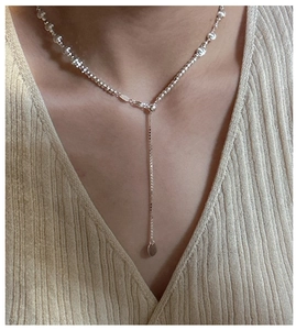 Detail of S925 sterling silver Y-shaped necklace with cat eye beads on model