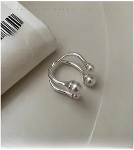 Detail of silver double-layered crossover ring featuring four various-sized white pearls