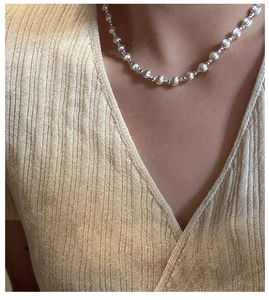 Close-up of polished S925 sterling silver beaded necklace on a model's neck