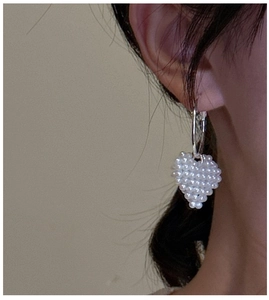 Gros plan d'une boucle d'oreille cœur en perles tressées avec fermoir argenté