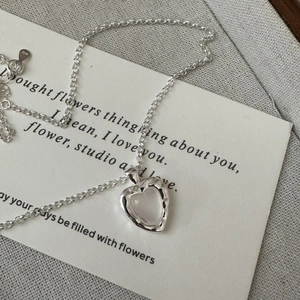 Collier coeur en argent S925 avec texture de lave sur une carte artistique blanche