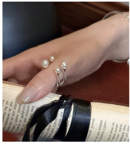 Detail of S925 silver double-layered open ring with elegant white pearls on hand