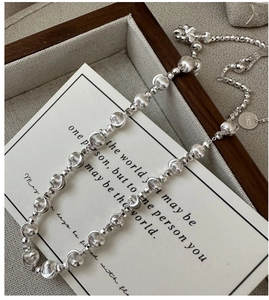 Detailed view of S925 sterling silver beaded necklace with brushed texture and faceted metal