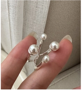 Macro detail of S925 silver ring featuring four white pearls in a crisscross design