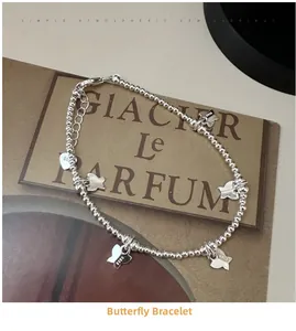 Détail du bracelet en argent S925 avec cinq breloques papillons et un pendentif coeur