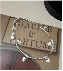 Détail d'un bracelet en argent sterling S925 avec des breloques papillon délicates