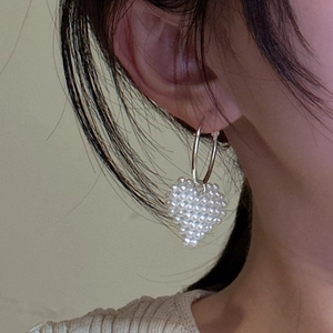 Boucles d'oreilles cœur en perles tressées argent S925 portées par un mannequin style rétro