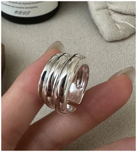 Gros plan d'une bague ouverte en argent S925 avec un design triple couche poli