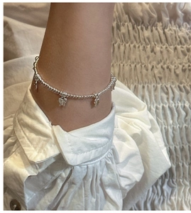 Détail d'un bracelet papillon en argent sterling S925 porté au poignet d'une femme