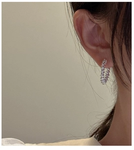 Detail of S925 sterling silver hoop earring with sparkling micro-pave crystals on model