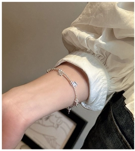 Gros plan d'un bracelet double rang en argent 925 avec perles et breloques animales au poignet