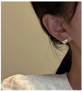 Minimalist S925 sterling silver heart-shaped stud earring worn on the earlobe