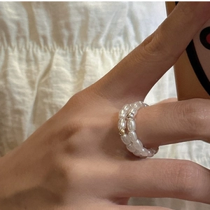 Dettaglio di un anello a doppio strato in argento S925 con perle di riso bianche e perline