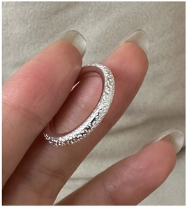 Detailed macro view of S925 sterling silver ring with unique textured surface and relief pattern