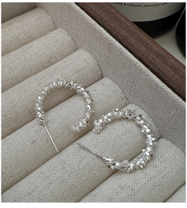 Detailed macro view of S925 sterling silver hoop earrings with textured crushed silver finish