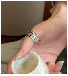 Détail d'une bague multicouche minimaliste en argent S925 sur le pouce du mannequin