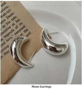 Detailed close-up of S925 sterling silver crescent moon earrings with a polished finish