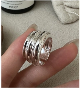 Détail de la bague large en argent S925 avec texture ondulée multicouche sur la main