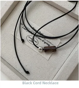 Detail of S925 silver square bead and dark wood cylinder on black cord necklace