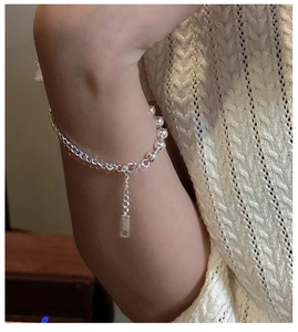 Close-up of S925 sterling silver bead bracelet with lobster clasp on a knitted sweater