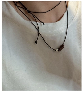 Macro detail of S925 silver bead and wood pendant on adjustable black wax cord necklace