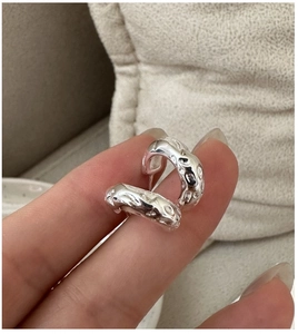 Detailed view of S925 sterling silver hoop earrings with unique hammered lava texture