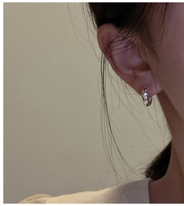 Close-up of polished S925 sterling silver earring with irregular textured crinkle design