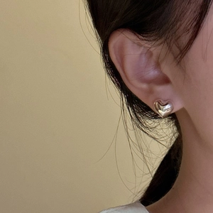 Minimalist S925 sterling silver heart stud earring with polished finish on model ear