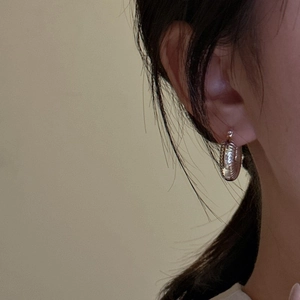 Minimalist S925 sterling silver hoop earrings with a textured ribbed design on model
