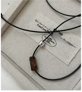 Detail of S925 silver necklace with black wax rope and wood cylindrical bead