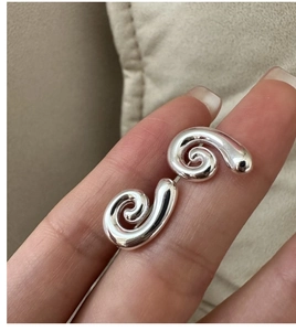 Macro shot of minimalist S925 sterling silver spiral earrings with polished mirror finish