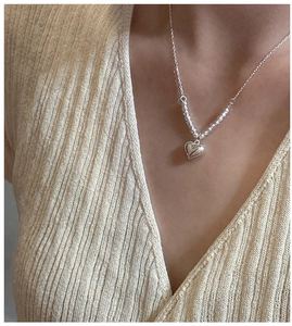 Close-up of S925 silver heart necklace with laser beads on female model neckline