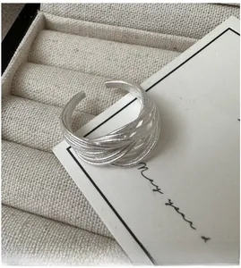 Détail macro d'une bague multicouche en argent au fini brossé mat avec anneau ouvert