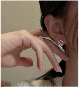 Macro shot of silver conch shell stud earrings on model with high mirror finish