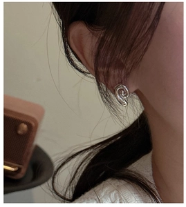 Macro shot of S925 sterling silver conch earrings with spiral texture on female ear