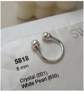 Macro shot of 8mm white pearls on a minimalist S925 silver open U-shaped ring