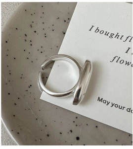 Detail eines minimalistischen S925 Silberrings mit geometrischem Design auf Marmor