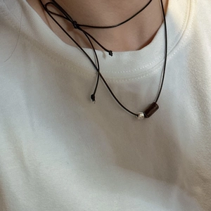 Minimalist S925 silver necklace with dark wood cylinder and black waxed cord on model
