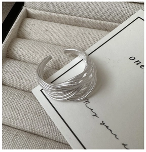 Vue macro d'une bague ouverte multicouche minimaliste en argent S925 avec finition mate