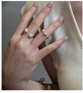 Close-up of elegant S925 sterling silver pearl rings on a hand with minimalist design