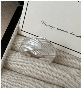 Vue macro d'une bague ouverte multicouche entrelacée en argent S925 au style épuré