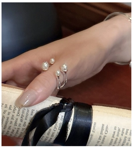 Detail of S925 sterling silver open ring featuring elegant white pearls on a hand