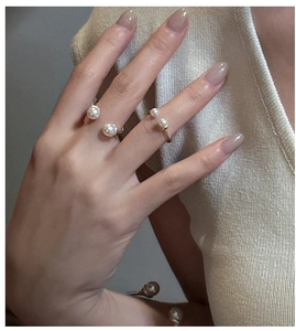 Close-up of elegant S925 silver gold-plated pearl rings and bracelet set worn on hand