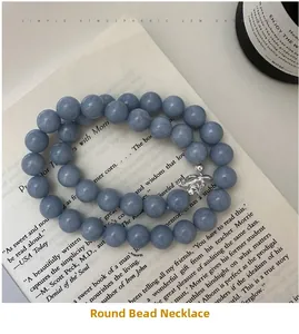Detail view of blue-grey beaded S925 sterling silver necklace with flower clasp