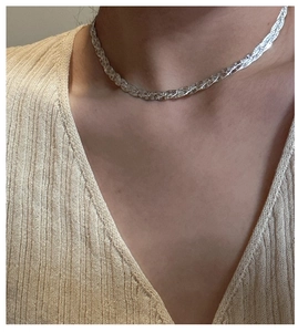 Close-up of S925 sterling silver triple layered braided necklace on a female model