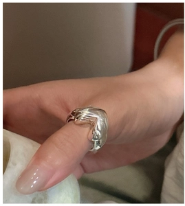 Close-up of a bold silver S925 heart ring with a polished finish on a model finger
