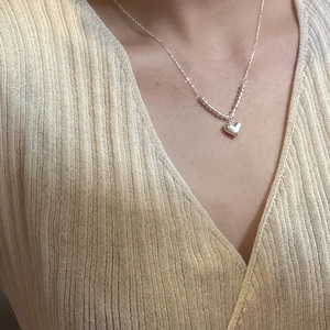 Elegant S925 sterling silver heart necklace worn by model with minimalist beaded chain