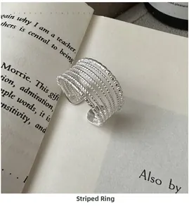 Minimalist S925 silver multi-layer wire ring displayed on an open vintage book page