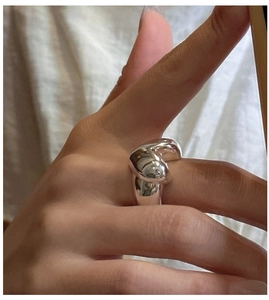 Close-up of S925 sterling silver heart ring worn on hand with polished finish
