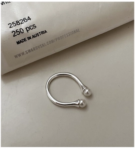Macro shot of S925 sterling silver open ring with dual white pearls in a horseshoe design